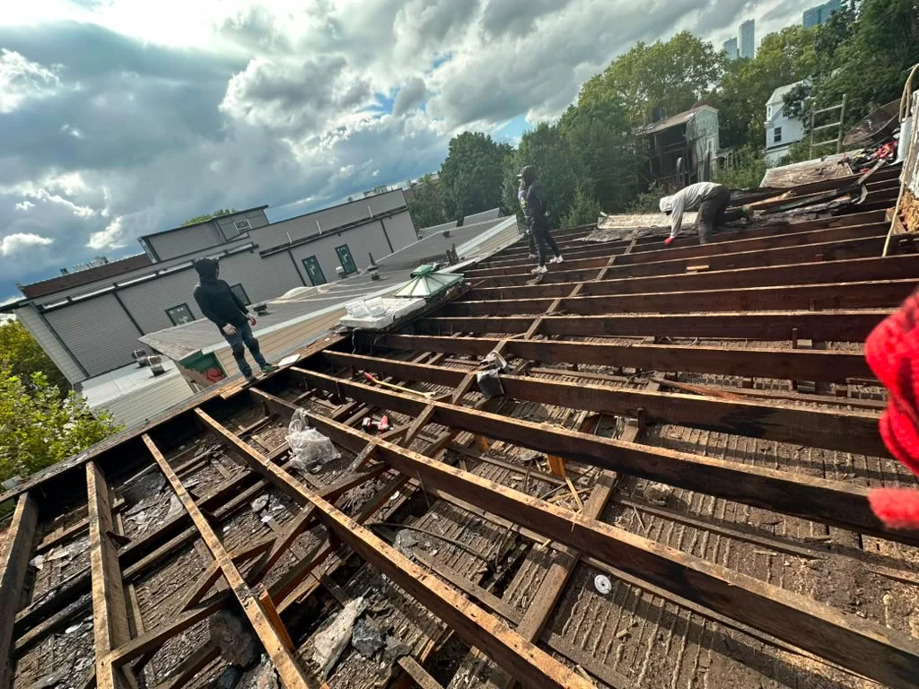Exposed roof framing and old decking during a Jersey City flat roof replacement