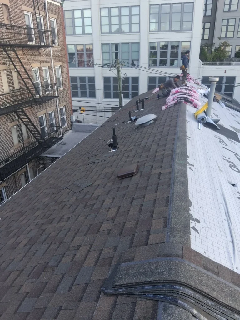Roofing crew working around vents during a Jersey City asphalt shingle reroof