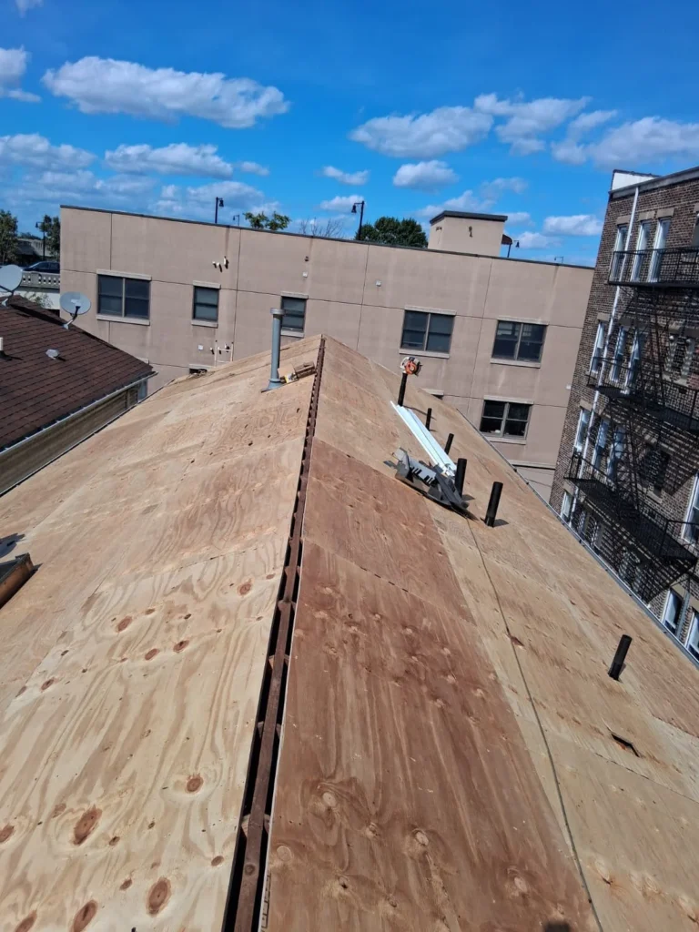 Replacement plywood sheathing installed across a Jersey City hip roof