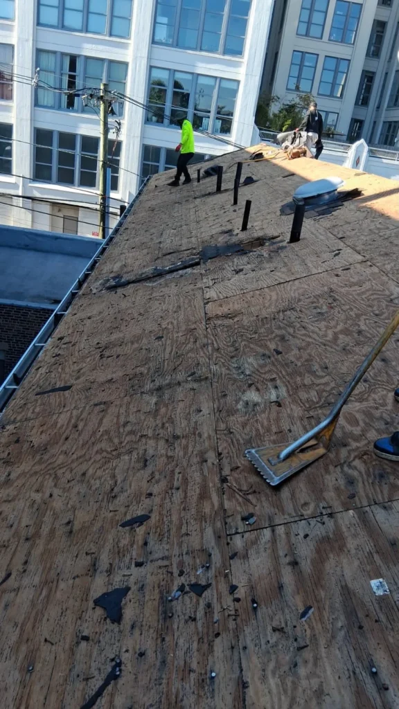Deteriorated roof deck and removed shingles during a Jersey City roof replacement