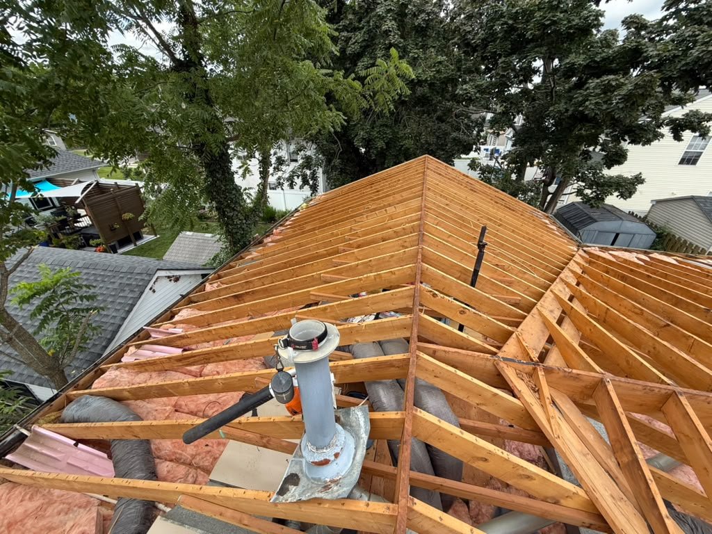 Existing rafters, insulation, and attic ductwork during a Toms River roof replacement