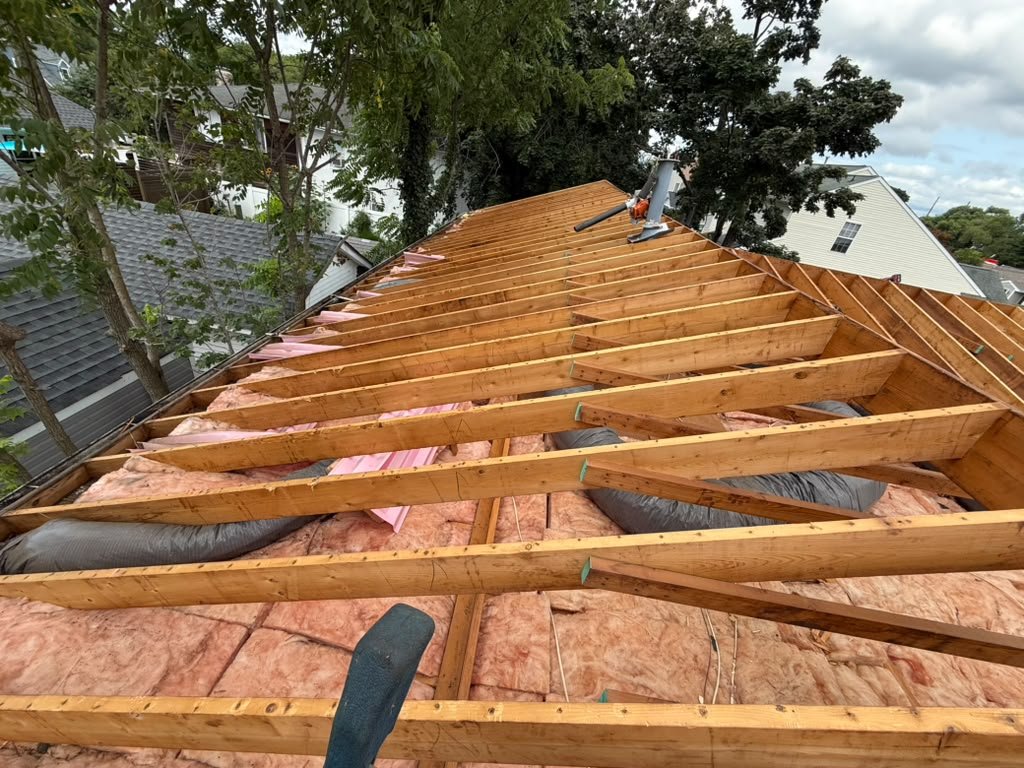 Open roof framing and existing attic insulation in Toms River