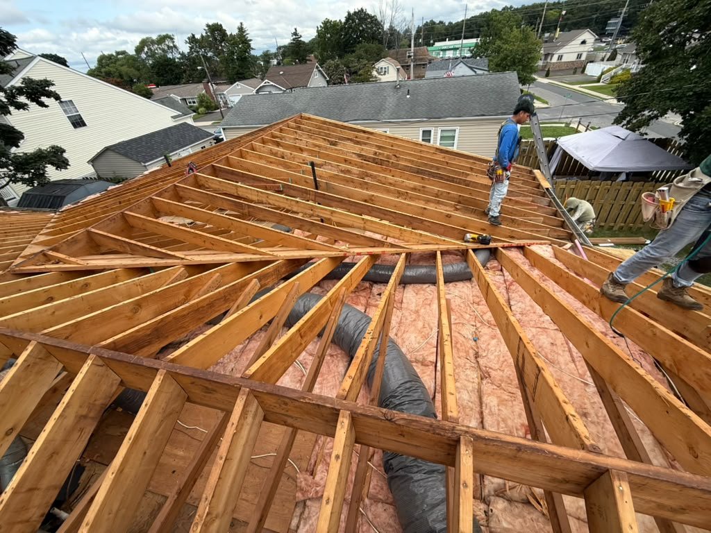 Existing rafters and attic ductwork exposed during a Toms River reroof