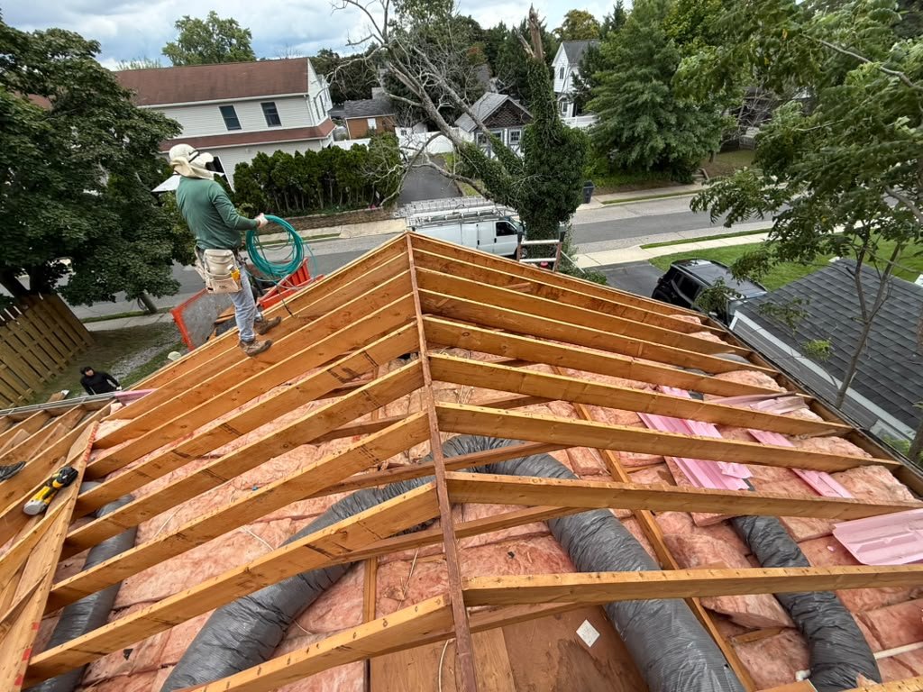 Existing roof rafters and insulation before new plywood sheathing in Toms River