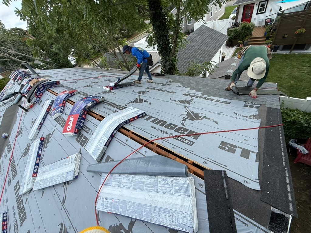 Roofing crew installing STINGER EXO25 underlayment during a Toms River roof replacement