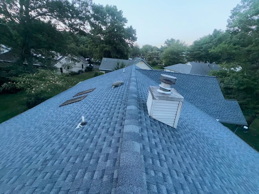 Completed roof replacement with chimney and vent details in Whiting