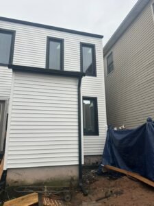 Finished white horizontal siding and black window trim on a Weehawken NJ home